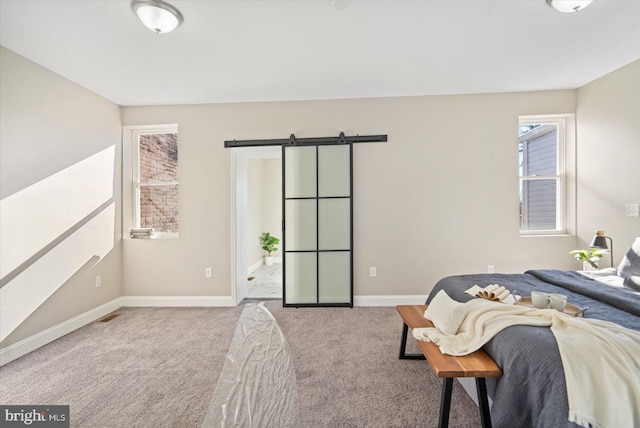 carpeted bedroom featuring a barn door