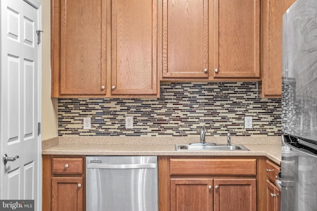 kitchen featuring decorative backsplash, sink, and stainless steel dishwasher