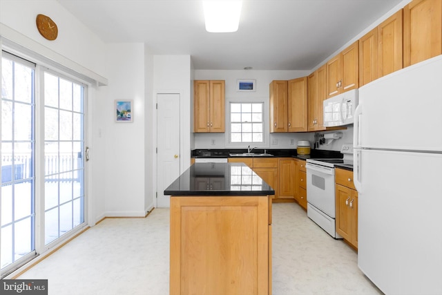 kitchen featuring white appliances, a center island, and sink