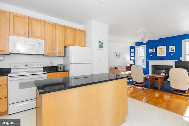 kitchen with a center island, white appliances, dark stone counters, light hardwood / wood-style flooring, and ceiling fan