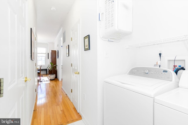 laundry room with separate washer and dryer and hardwood / wood-style floors