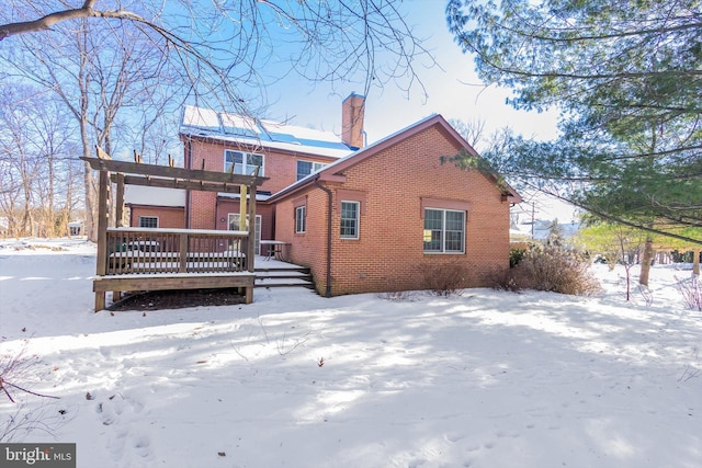 snow covered rear of property featuring a wooden deck