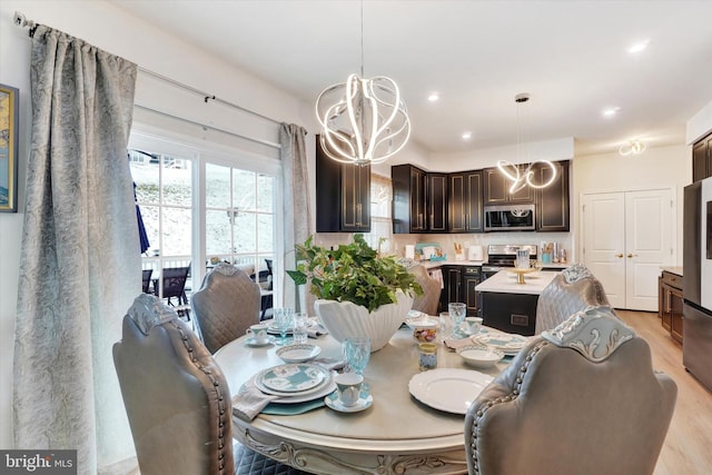 dining area featuring light hardwood / wood-style floors and a notable chandelier