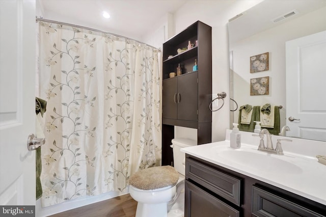 bathroom with a shower with curtain, vanity, toilet, and wood-type flooring