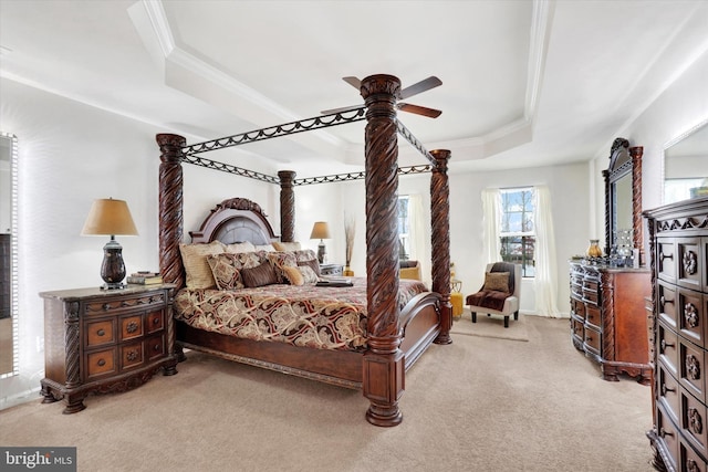 carpeted bedroom featuring ceiling fan and a tray ceiling