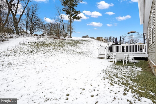 yard covered in snow with a wooden deck