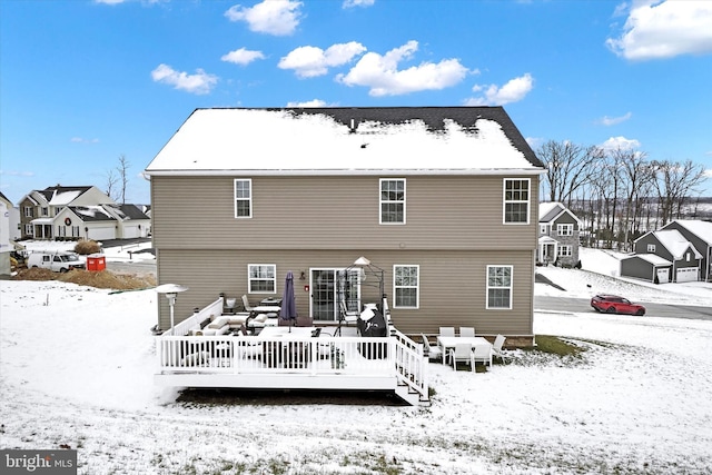 snow covered rear of property featuring a deck