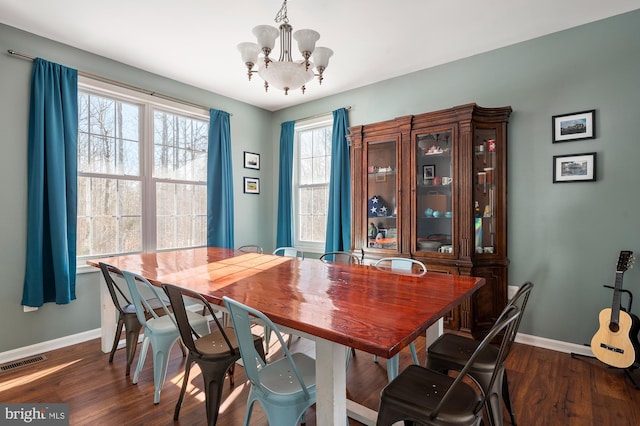 dining area with a notable chandelier and dark wood-type flooring