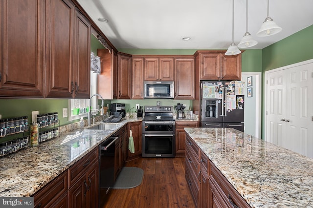 kitchen with appliances with stainless steel finishes, hanging light fixtures, light stone countertops, dark hardwood / wood-style flooring, and sink