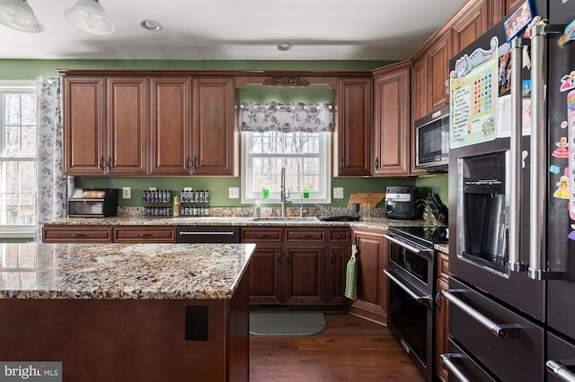 kitchen with stainless steel appliances, dark hardwood / wood-style flooring, sink, and light stone counters