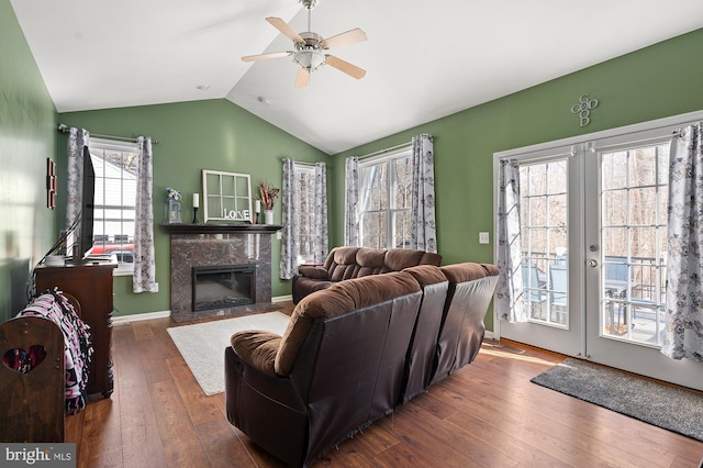 living room featuring ceiling fan, dark hardwood / wood-style floors, plenty of natural light, and a fireplace