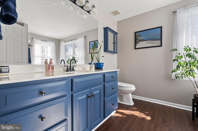 bathroom with toilet, wood-type flooring, and vanity