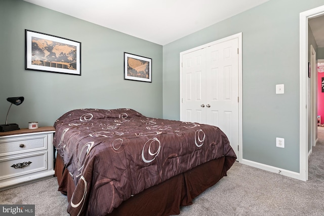 bedroom featuring light colored carpet and a closet