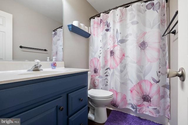 bathroom with toilet, a shower with shower curtain, and vanity