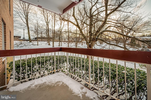 view of snow covered back of property