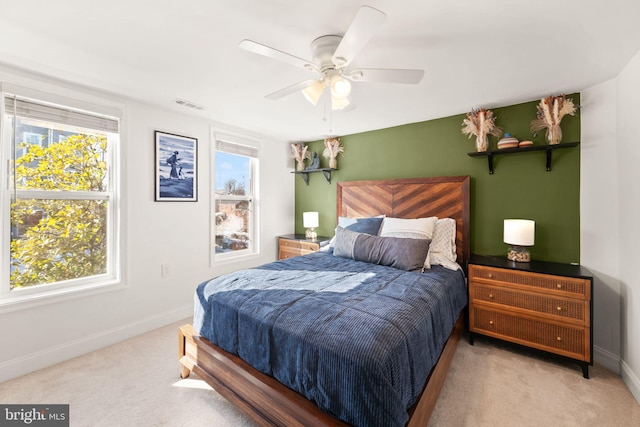 carpeted bedroom featuring multiple windows and ceiling fan