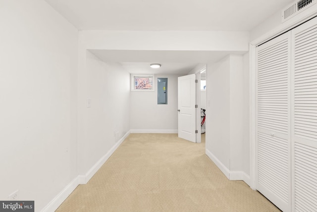 hallway featuring electric panel and light carpet