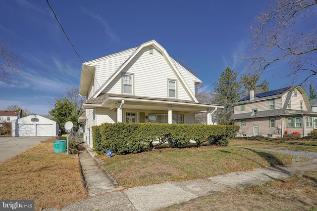 view of front facade with an outbuilding, a front lawn, and a garage