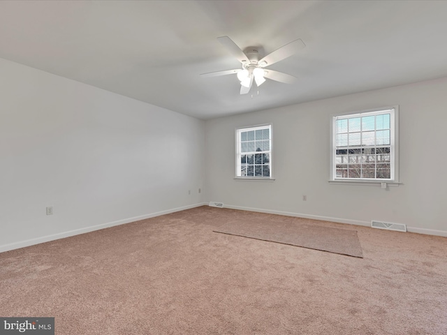 spare room featuring ceiling fan and carpet