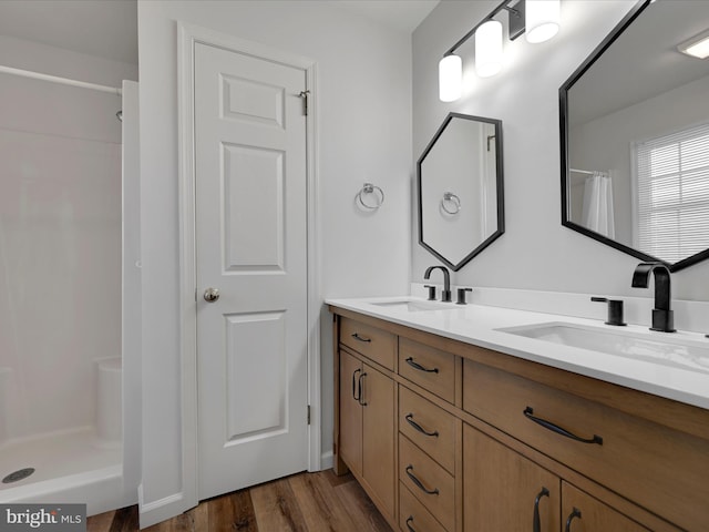 bathroom featuring vanity, wood-type flooring, and walk in shower