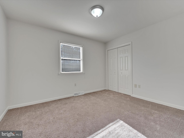 unfurnished bedroom featuring a closet and carpet floors