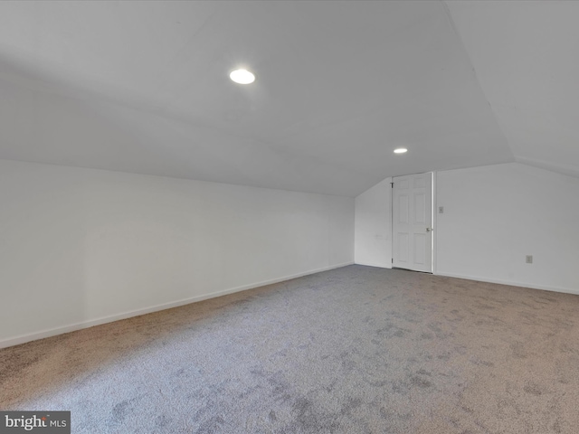 additional living space featuring lofted ceiling and carpet floors