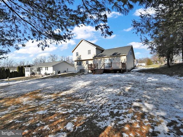 snow covered property with a wooden deck