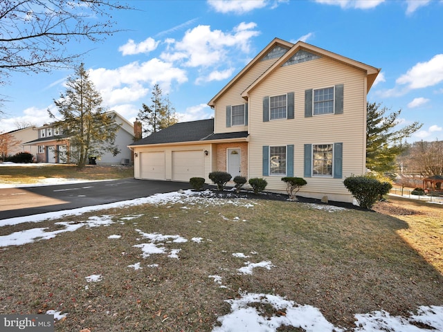 view of front of property featuring a garage and a lawn