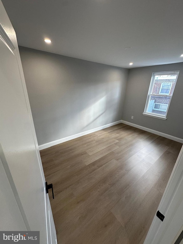 unfurnished room with hardwood / wood-style flooring