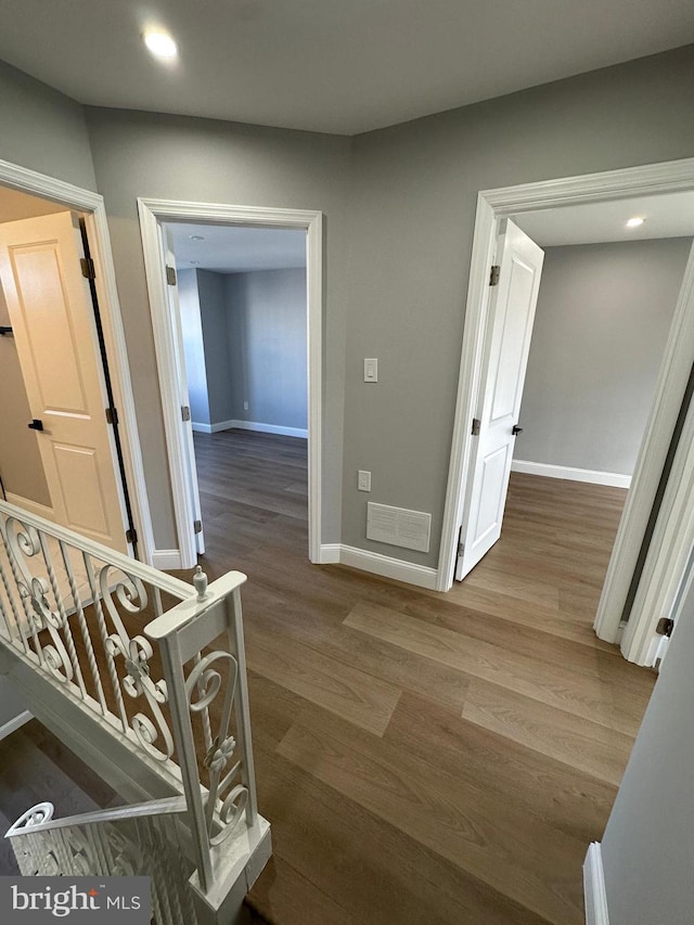 corridor with hardwood / wood-style floors