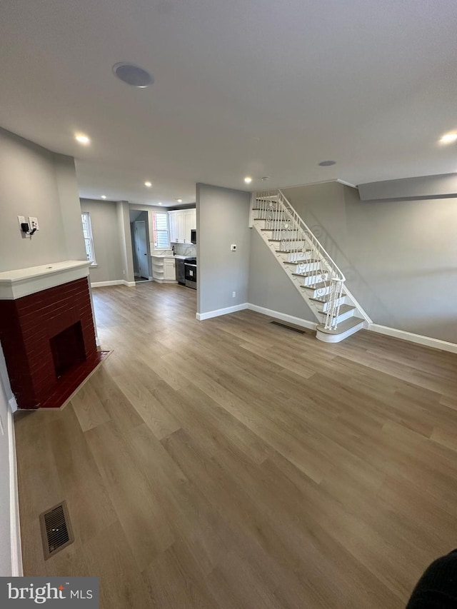 unfurnished living room featuring a fireplace and hardwood / wood-style flooring