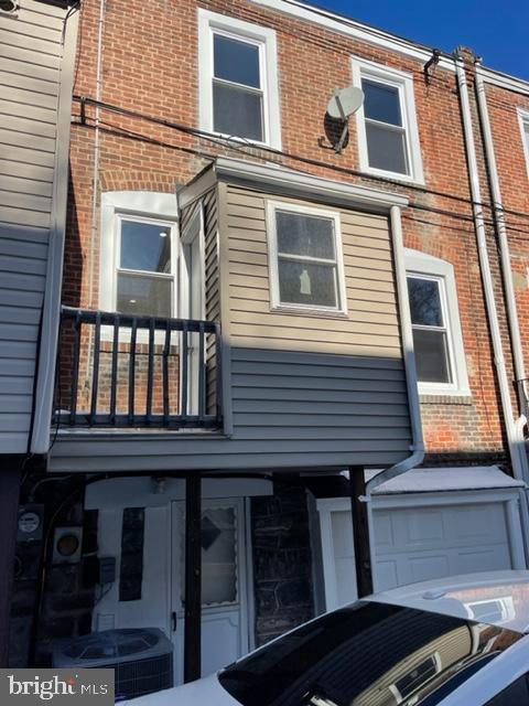 view of side of home with central AC unit and a balcony