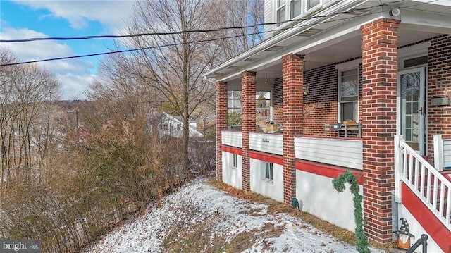 view of snow covered exterior featuring a porch