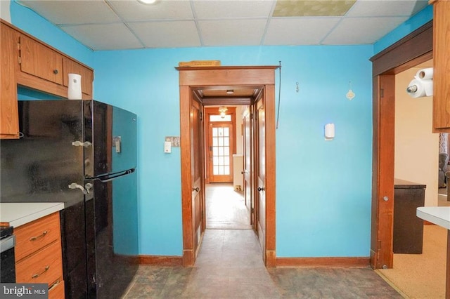 kitchen with black refrigerator and a drop ceiling