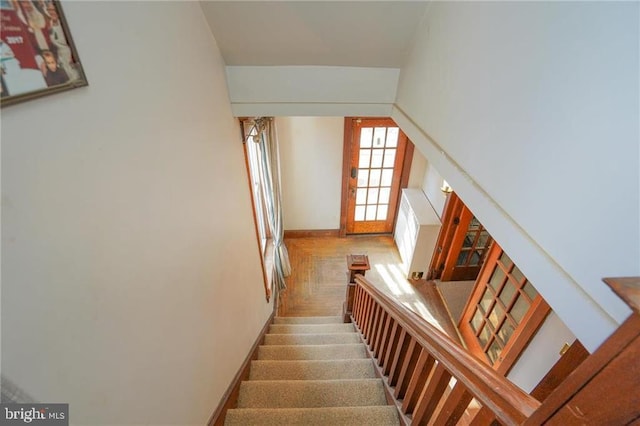 stairs featuring parquet flooring