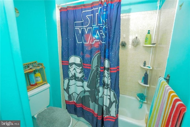 bathroom with tile patterned floors, shower / bath combo with shower curtain, and toilet