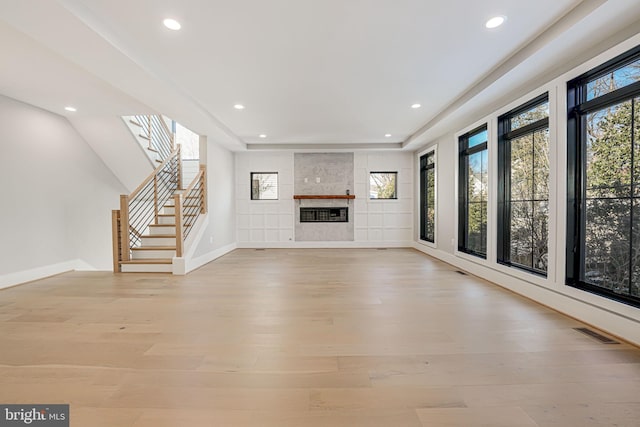 unfurnished living room with a fireplace and light wood-type flooring