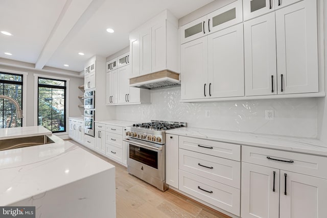 kitchen featuring light stone counters, appliances with stainless steel finishes, sink, and white cabinets