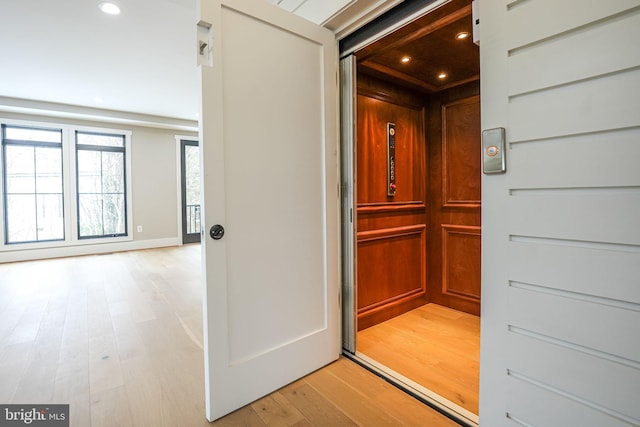 interior space with hardwood / wood-style floors and elevator