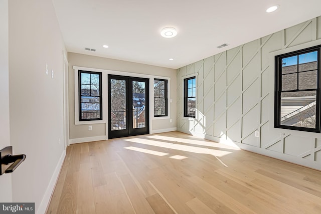 unfurnished room with light hardwood / wood-style floors and french doors
