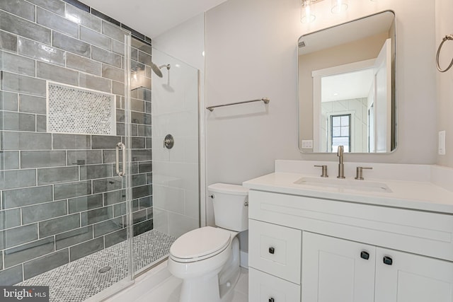 bathroom featuring walk in shower, vanity, and toilet