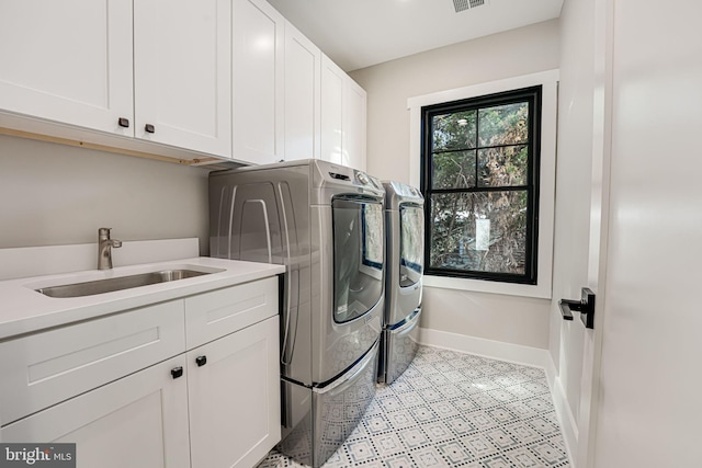 laundry room with cabinets, sink, and washer and clothes dryer