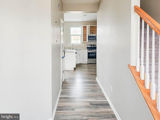 corridor with sink and hardwood / wood-style floors