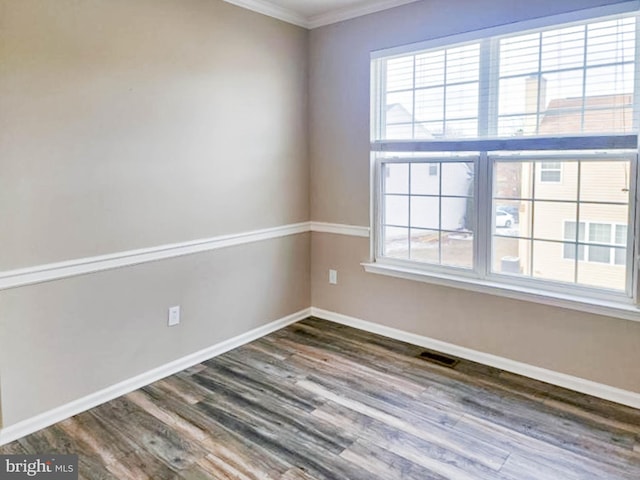 empty room featuring dark hardwood / wood-style floors and ornamental molding