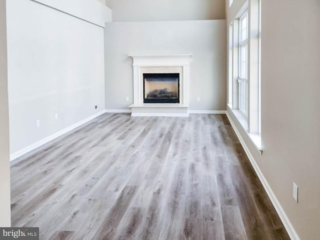 unfurnished living room with a wealth of natural light and light hardwood / wood-style flooring