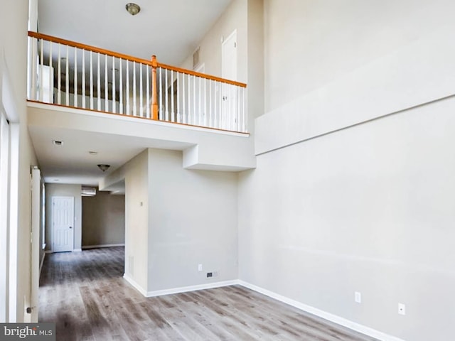 stairway with hardwood / wood-style floors and a towering ceiling