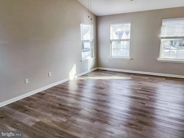 unfurnished room with dark wood-type flooring and lofted ceiling