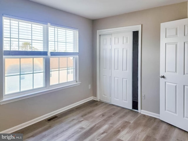 unfurnished bedroom featuring light wood-type flooring and a closet