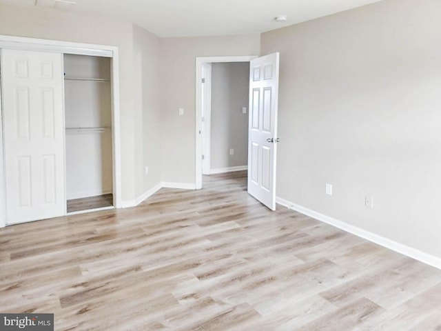 unfurnished bedroom with light hardwood / wood-style flooring and a closet