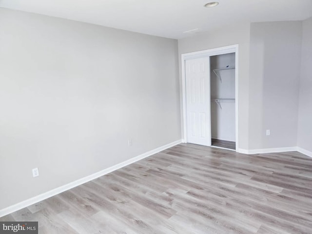 unfurnished bedroom featuring a closet and light hardwood / wood-style floors